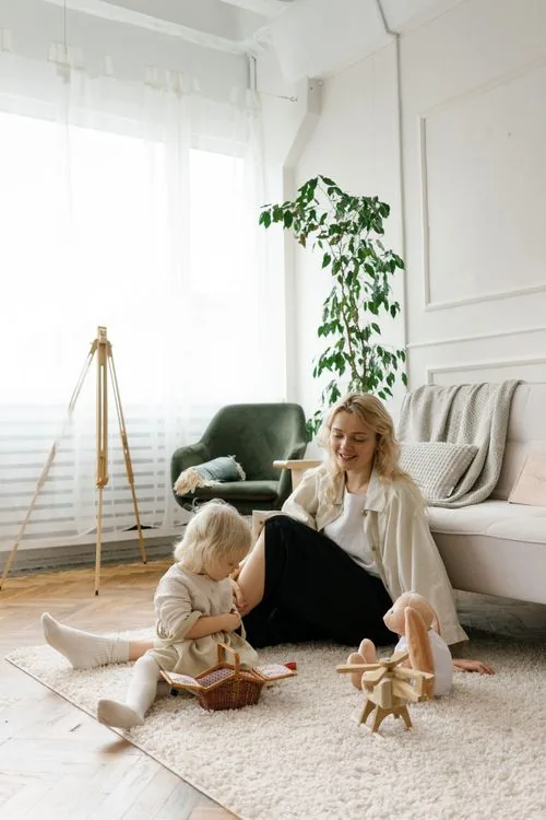 A mother and her young daughter playing with wooden toys at home